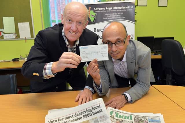 David Stott from the National Police Aid Convoy recieves the cheque from Ahmed Suleman, director Savana Rags.
