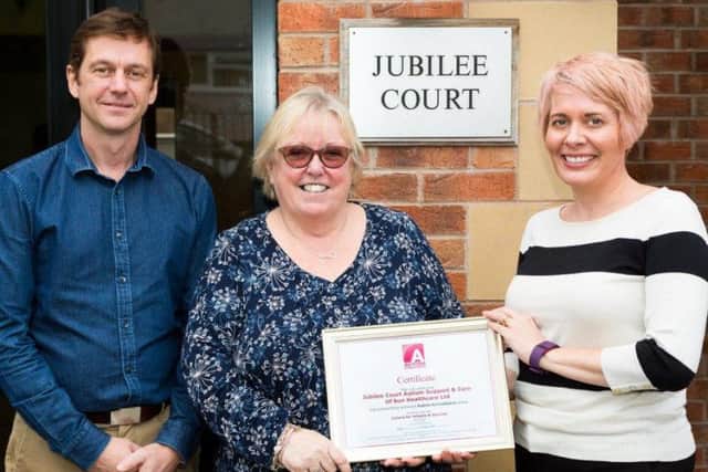 A certificate is handed to home manager Marie Fitzpatrick (centre) by Stephanie de Vries, of the National Autistic Society, watched by Alan Tolan, of Sun Healthcare.