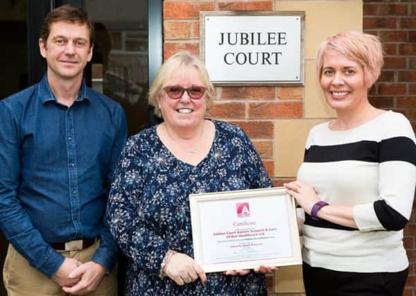 A certificate is handed to home manager Marie Fitzpatrick (centre) by Stephanie de Vries, of the National Autistic Society, watched by Alan Tolan, of Sun Healthcare.