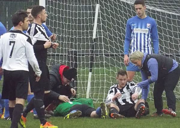 Injured Teversal goalkeeper Josh Turton is treated for concussion before having to go off. (PHOTO BY: Keith Parnill)