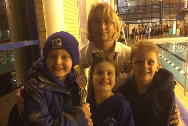 Sutton trio Finley Hollingworth (left), Anna Woodhall (centre) and Evan Hawley with the winners' trophy.