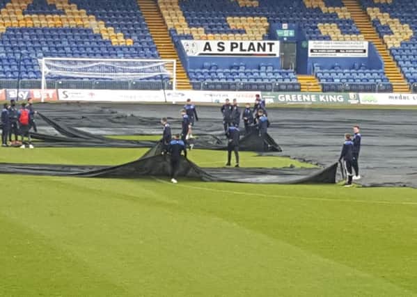 The covers go on at One Call Stadium today to protect the pitch from frost ahead of the big cup tie with Wycombe
