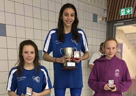 Hollie-Mae Dove on the podium after retaining her 100m breaststroke title. Third was Sutton teammate Ellethea Hawley.