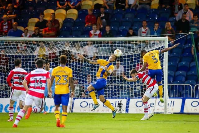Mansfield Town's George Taft heads clear - Pic Chris Holloway