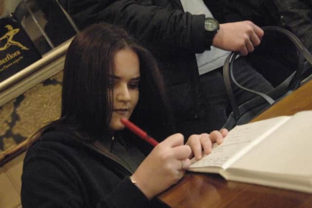 Friend Aleah Hindley signs the book of condolence.