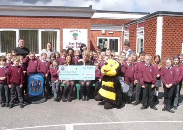 Leas Park Junior School receiving a cheque from Four Seasons mascot Buzz after last years Shop For Schools.