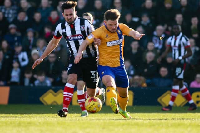 Mansfield Town's Alex MacDonald battles with ex Stag Chris Clements - Photo by Chris Holloway
