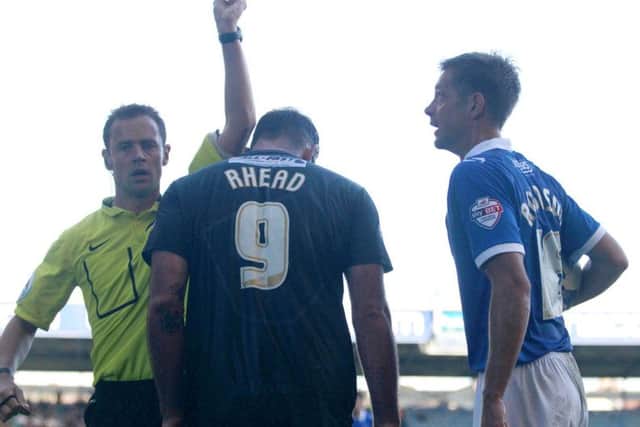 Referee Stuart Atwell shows the yellow card to Matt Rhead after clashing with Portsmouth's Johnny Ertl -Pic by: Richard Parkes