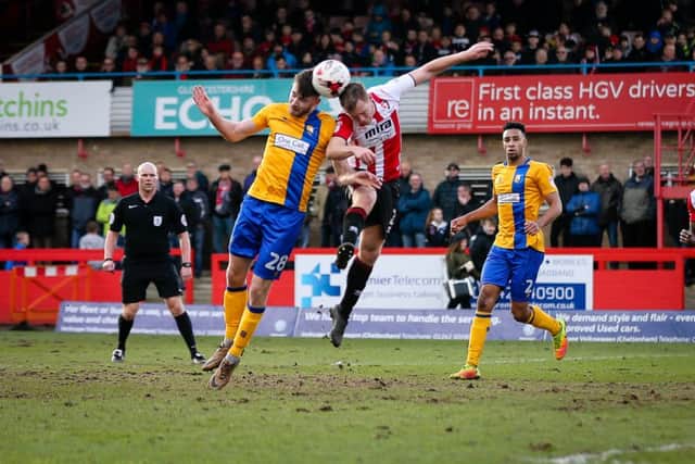 Mansfield Town's Ben Whiteman wins the header - Photo by Chris Holloway
