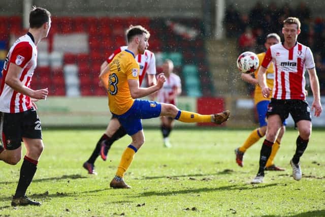 Mansfield Town's Ben Whiteman passes the ball on - Photo by Chris Holloway