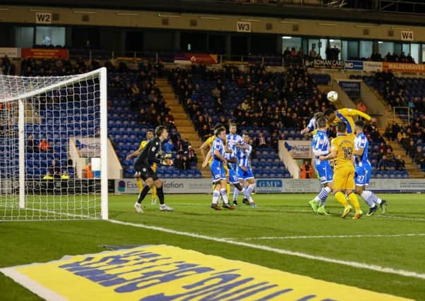 Mansfield Town's Krystian Pearce wins the header at Colchester on Tuesday  - Photo by Chris Holloway