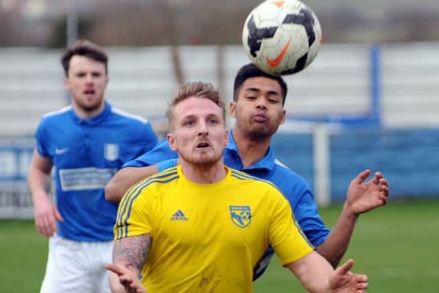 Selstons Elliott Jones (in yellow) in action against South Normanton earlier this month. His side are favourites for the title and also have a cup final to look forward to.