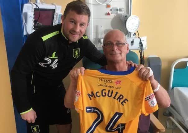 Howard Richardson receives the signed shirt from Stags midfielder Jamie McGuire. PHOTO: Courtesy Mansfield Town