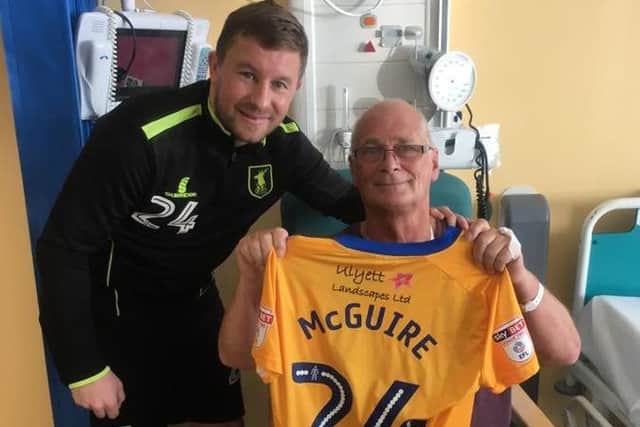 Howard Richardson receives the signed shirt from Stags midfielder Jamie McGuire. PHOTO: Courtesy Mansfield Town