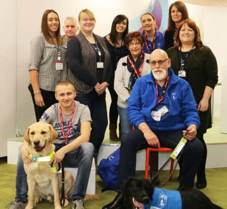 Puppy Nathan with his ex-student namesake, Nathan Edge and his own guide dog, Nichola Bonsall, of the Guide Dogs charity, and the visual impairment team at West Notts College
