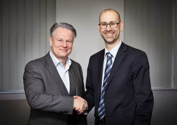 Martyn Knox, managing partner of Hopkins, and Mark Slade, managing partner of Fidler and Pepper, shake on the deal.