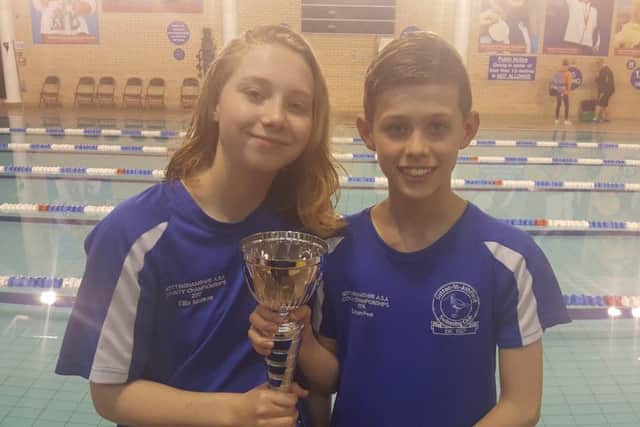 Two members of Sutton Swimming Club's A team with the runners-up trophy.