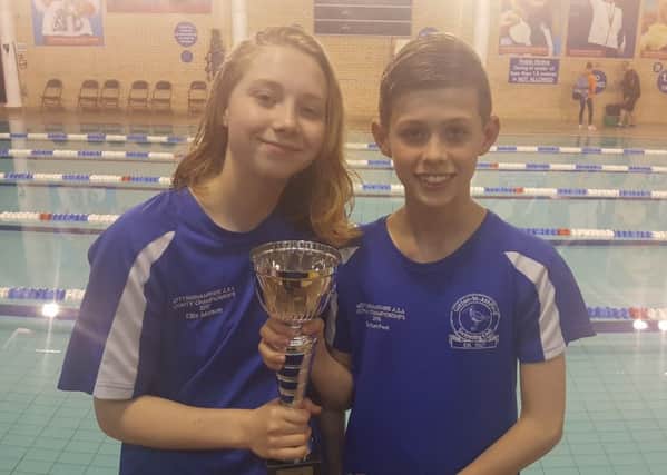 Two members of Sutton Swimming Club's A team with the runners-up trophy.