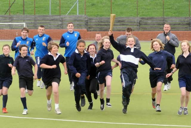 Manor Academy student Charlie Hardwick takes the lead with an olympic torch to launch the new Inspiring Mansfield sports event . Pictured running with other students and stags players Scott Rogers,Joel Holland,Jobe Shaw and Mansfield football in the community staff Mark Lynk,Jordan Ferrer, Gary Shaw