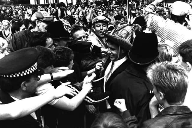 Kevin Hitchcock, wearing the Mexican hat, is swamped by fans at the open-top bus parade celebrations a day after Wembley.