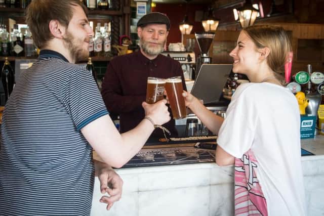 Joby Andrews talks to a young voter during the launch of the Vote This Year Get Free Beer campaign launch. Photo - SWNS