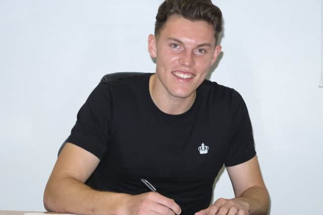 New boy Paul Digby signs on the dotted line for Stags.