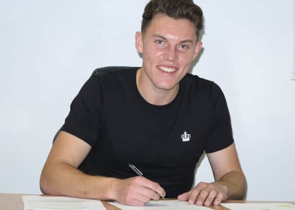 New boy Paul Digby signs on the dotted line for Stags.