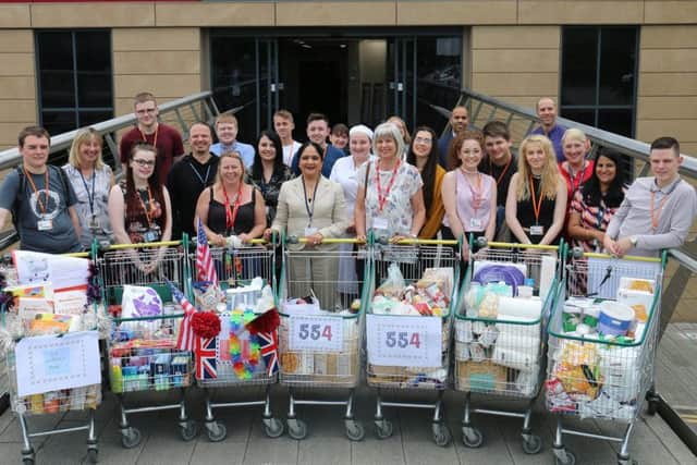 Andrea Lound, of Framework, and Tina Barnes, of the Hall Homeless Support Project, join students, staff and principal Dame Asha Khemka with the shopping trolleys.