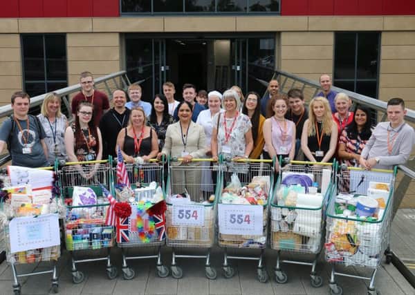 Andrea Lound, of Framework, and Tina Barnes, of the Hall Homeless Support Project, join students, staff and principal Dame Asha Khemka with the shopping trolleys.
