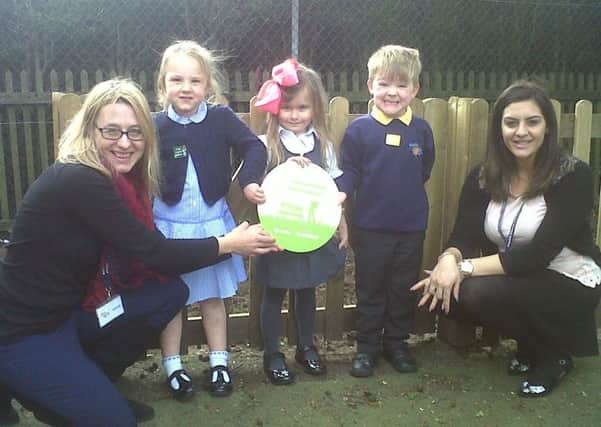 The county councils Lydia Powles hands a plaque to Asquith youngsters and teaching assistant, Thespo Yournimou.