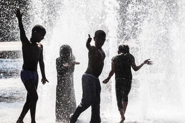 Children play in a water fountain as Britain basks in glorious sunshine and high temperatures.
