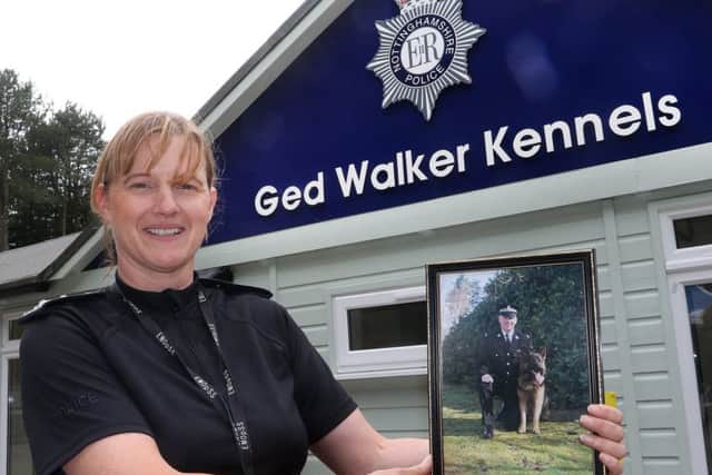 Inspector Annie Reavley, head of the dog section, with a photo of late colleague Ged Walker outside the newly named kennels. Picture: Jason Chadwick.