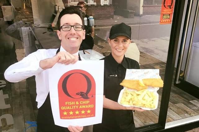Owner Theo Tsiolas shows the award with employee Hayley Jane Singlehurst outside the Jolly Fryer fish and chip shop..
