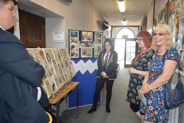 Parents and visitors admire the exhibition of art and photography.