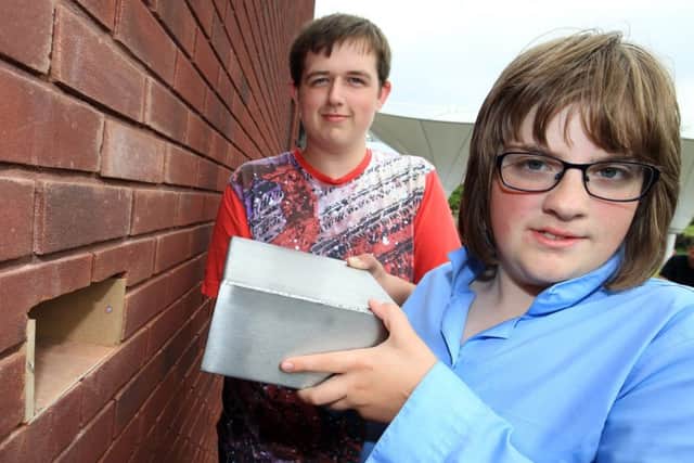 Pupils Dan Taylor and Abbie Storer with one of the time capsules at Stubbin Wood School.
