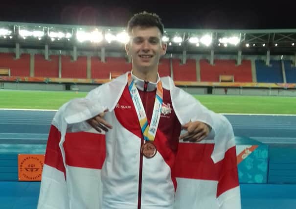 A jubilant Luke Duffy celebrates with the bronze medal he won at the Commonwealth Youth Games.