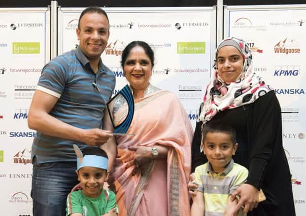 Syrian refugee Fahd Saleh (left) receives his award from Dame Asha Khemka, watched by his wife, Tahrir, and  sons, Omar and Nrur. (PHOTO BY: Tracey Whitefoot)