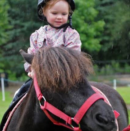 Summer Festival event at Titchfield Park.
Aniya Gilbert 2, braves a deluge for a pony ride.