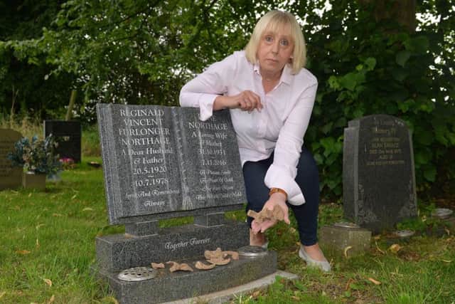 Elaine Mace pictured by her parents grave with the bones that she found on the surface