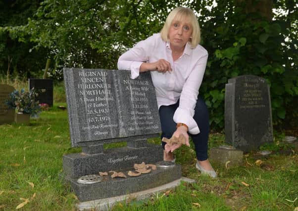 Elaine Mace pictured by her parents grave with the bones that she found on the surface