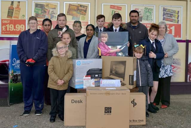 Computer equipment bought with money raised in memory of Ashlee Rowland handed over to her family at Kwik Stop, Glapwell. Picture includes Bali Kaur and Raj Singh of Kwik Stop Convenience Store, Raj Kaur of Bargain Booke, Julie Aitken of Glapwell Centre, Rose Aitken, Mathew Crowder, Mark Rowland and children Hollie Rowland, 13, Connor Cooper, 15, Kai Cooper, 14, Emily Rowland, six, Evie Rowland, 10 and Finlay Rowland, seven