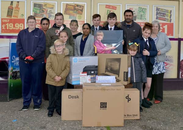 Computer equipment bought with money raised in memory of Ashlee Rowland handed over to her family at Kwik Stop, Glapwell. Picture includes Bali Kaur and Raj Singh of Kwik Stop Convenience Store, Raj Kaur of Bargain Booke, Julie Aitken of Glapwell Centre, Rose Aitken, Mathew Crowder, Mark Rowland and children Hollie Rowland, 13, Connor Cooper, 15, Kai Cooper, 14, Emily Rowland, six, Evie Rowland, 10 and Finlay Rowland, seven