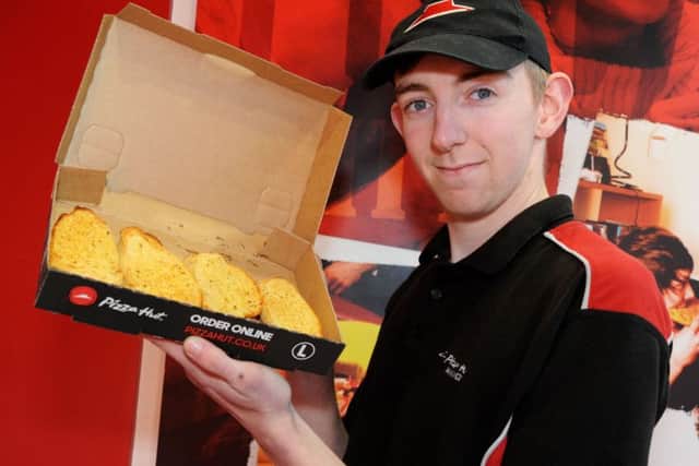 A Pizza Hut team member shows off the offer available in your Chad next week.