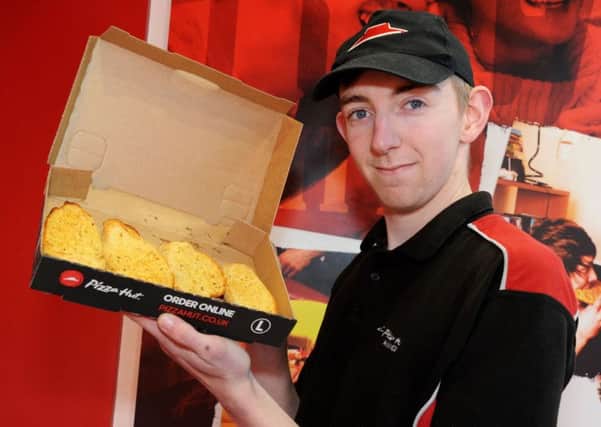 A Pizza Hut team member shows off the offer available in your Chad next week.