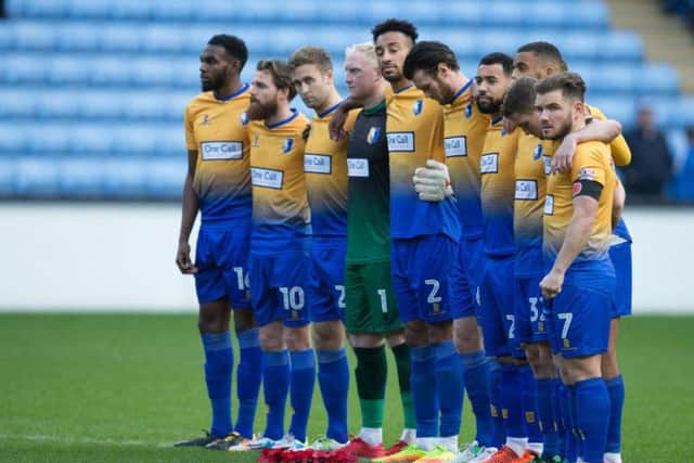 Mansfield Town players respectfully observe the minute's silence