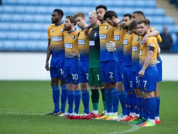 Mansfield Town players respectfully observe the minute's silence