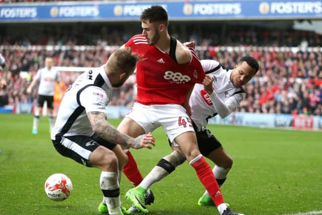 Nottingham Forests teenage striker Ben Brereton brushes off two Derby County defenders at the City Ground