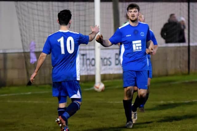 Lewis Bingham congratulates teammate Ben Bowring on scoring Ollertons fifth goal in the win at Brigg.