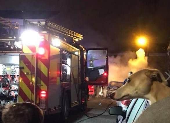 Firefighters battle the blaze which engulfed two cars