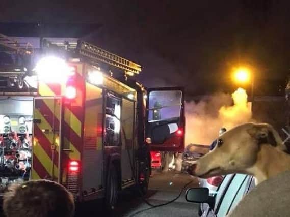 Firefighters battle the blaze which engulfed two cars